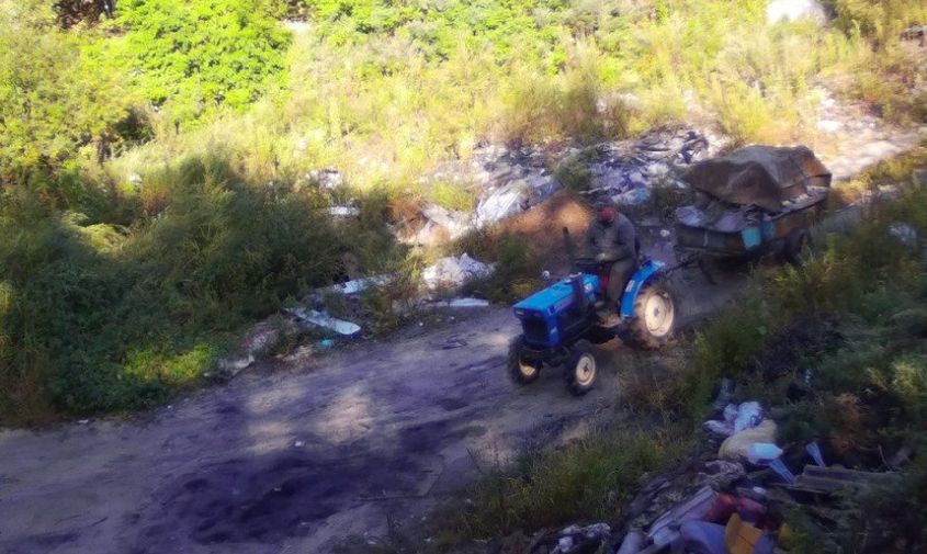 синий трактор выгрузил кучу мусора посреди дороги в моховой пади
