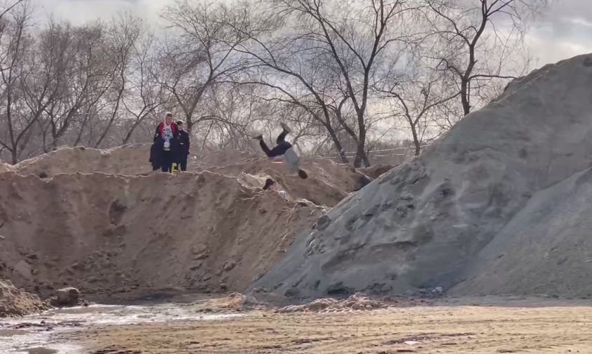благовещенские подростки кувыркаются на кучах песка, наваленных на вознесенском кладбище
